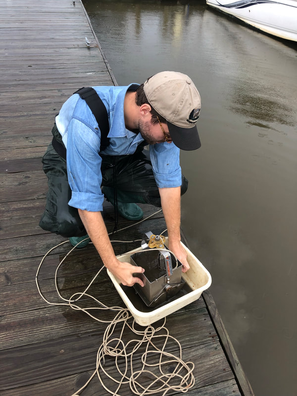Associate Scientist Taylor Sturm analyzing the contents of an Ekman-dredge in the Hudson River.